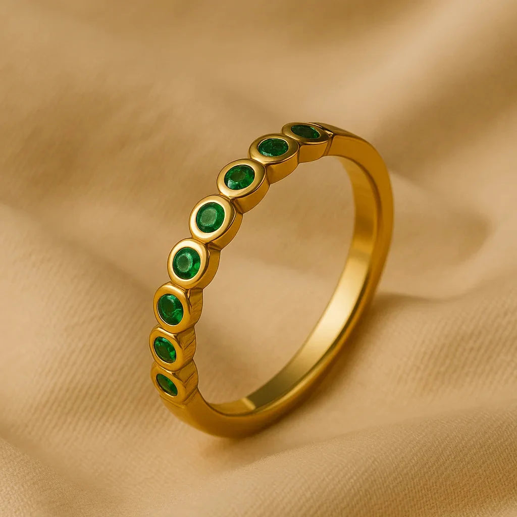 Anillo verde apoyado en tela dorada
accesorio garantia baño de oro 24k