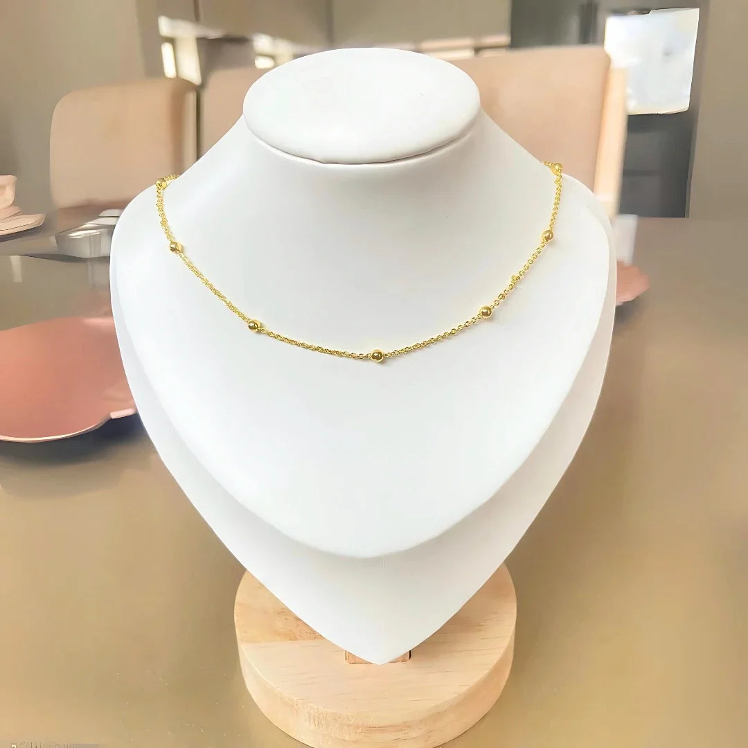Cadena de balines dorados exhibida en busto blanco. Accesorios mujer Bogotá