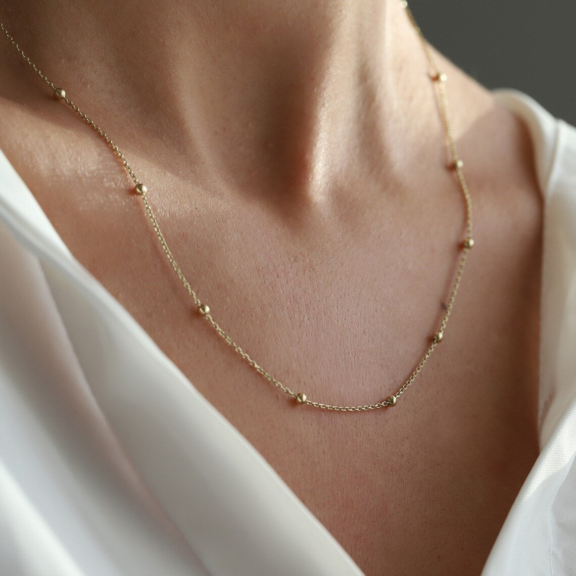 Cadena Esferas Baby usada por modelo, enfoque en cuello