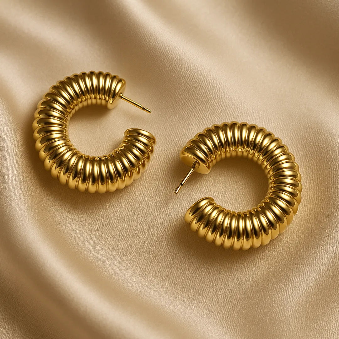 Accesorios tipo candonga dorada con textura espiral y brillo elegante