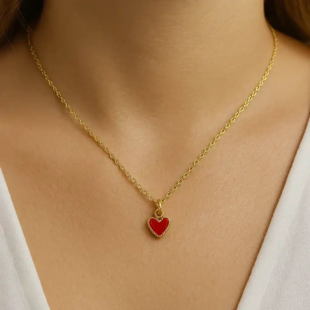 Collar importado en baño de oro 24K con dije rojo al cuello femenino. Accesorios importados mujer de lujo