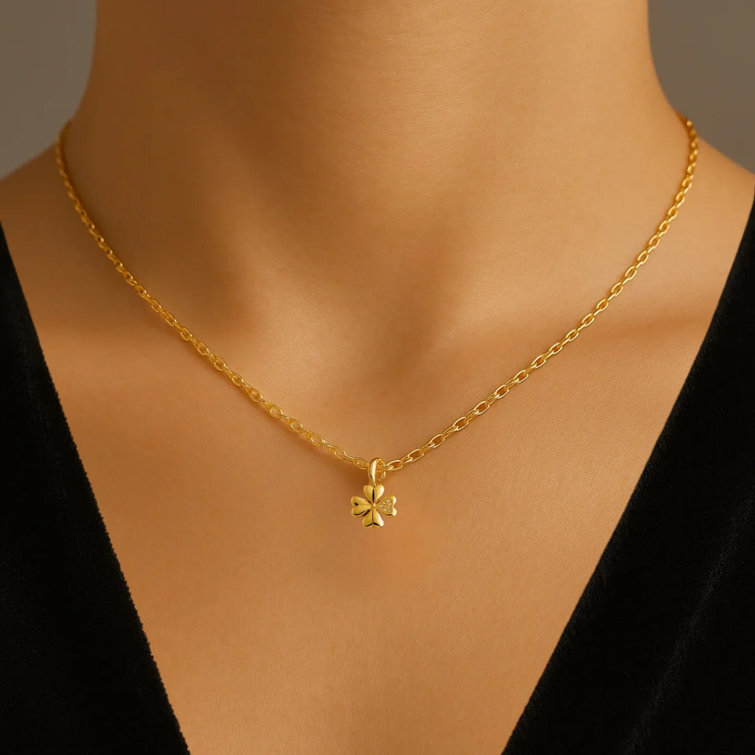 Mujer luciendo cadena dorada con dije de trébol minimalista
