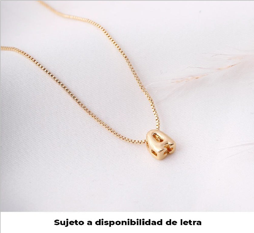 Mujer luciendo collar dorado con inicial, estilo delicado y elegante para uso diario