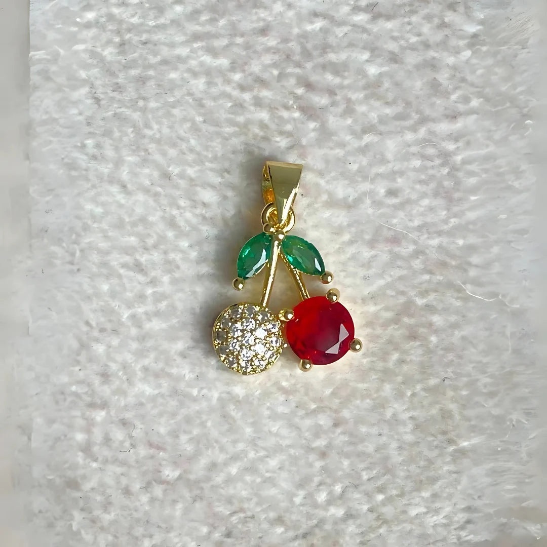 Detalle de dije cherry brillante con cristales sobre fondo neutro