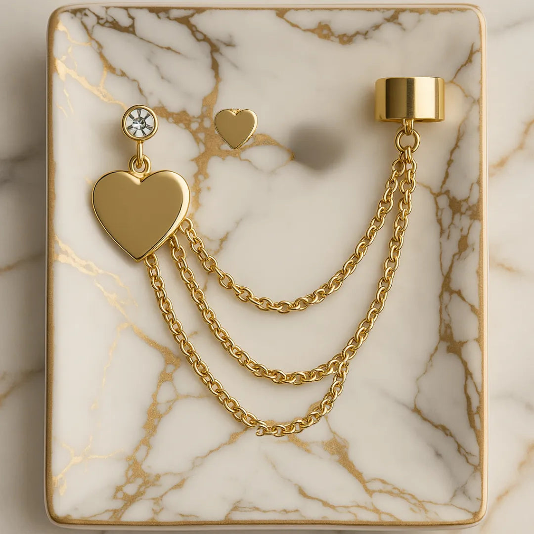 Topo y earcuff de corazones dorados con cadenas sobre bandeja, accesorios para mujer modernos y románticos.