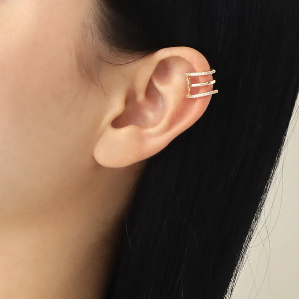 Ear cuff 3 aros puesto en oreja de modelo con cabello oscuro

