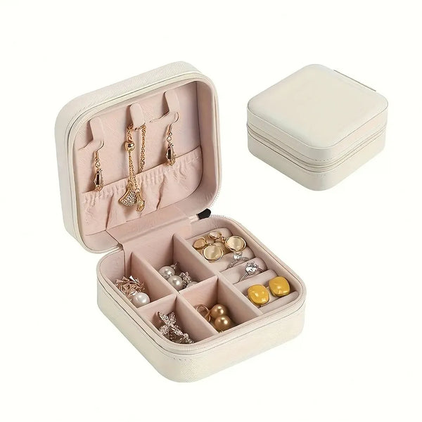 Joyero color beige abierto con joyas dentro yh otro joyero al lado cerrado, fondo blanco. Accesorios para mujer