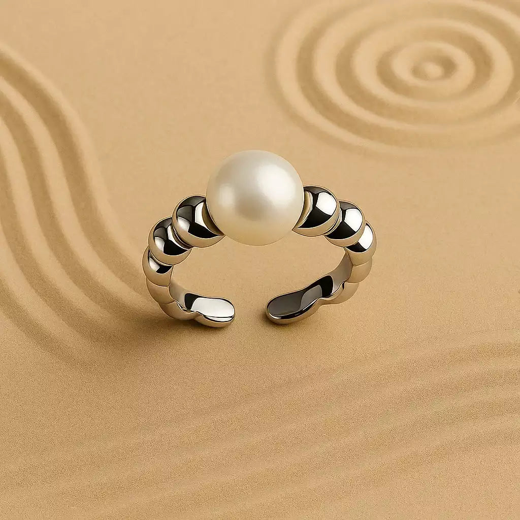 Anillo trenzado con perla en fondo beige. Accesorios mujer baño de oro 24k