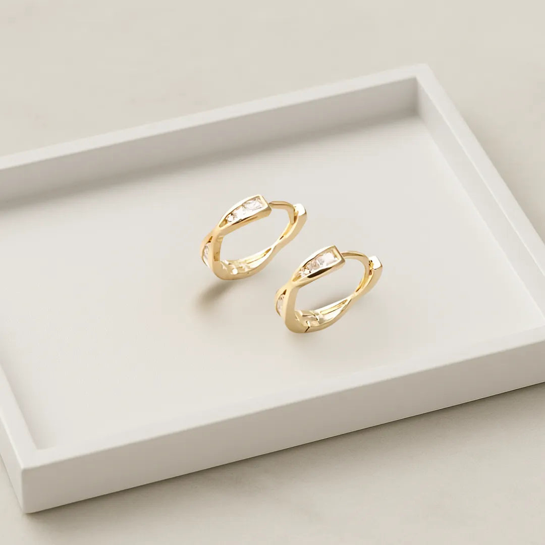 Aretes dorados sobre base cerámica con estilo sofisticado colombiano

