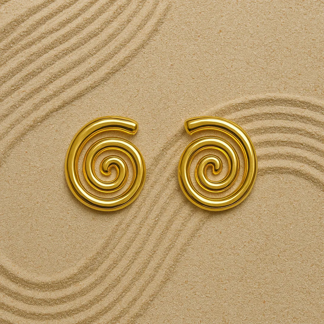 Aretes esculturales sobre fondo beige con textura suave

