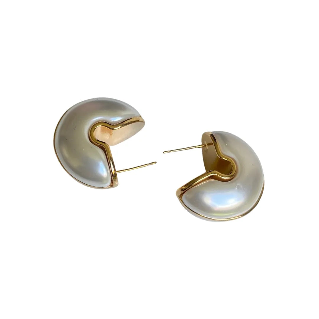 Vista frontal de aretes blancos con textura suave y diseño colombiano

