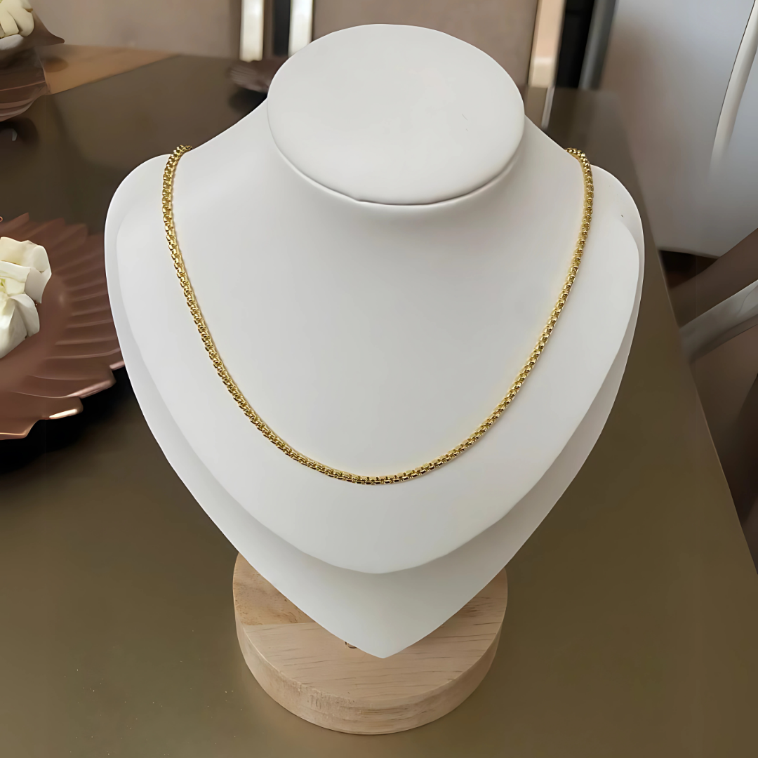 Cadena tipo espiga dorada con baño de oro 24K, ideal para mujer, vista sobre busto y modelo

