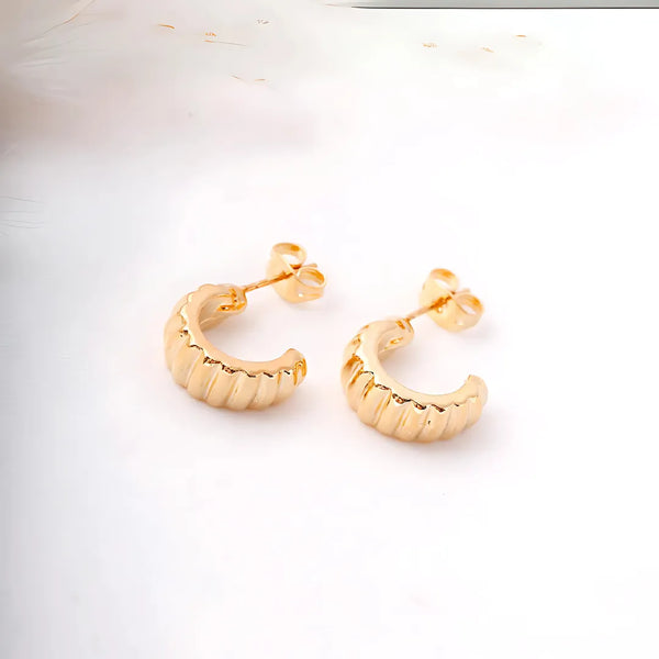 Aretes dorados pequeños tipo candonga con diseño en espiral sobre fondo claro – accesorios para mujer con estilo elegante