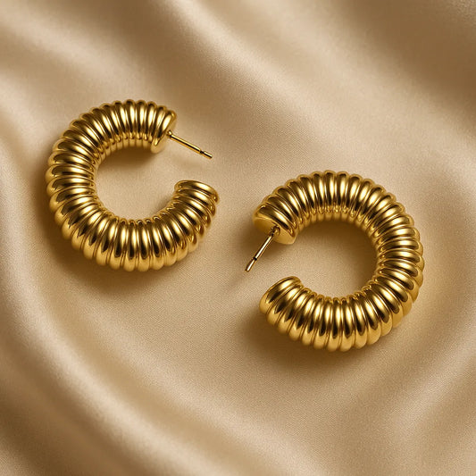 Accesorios tipo candonga dorada con textura espiral y brillo elegante

