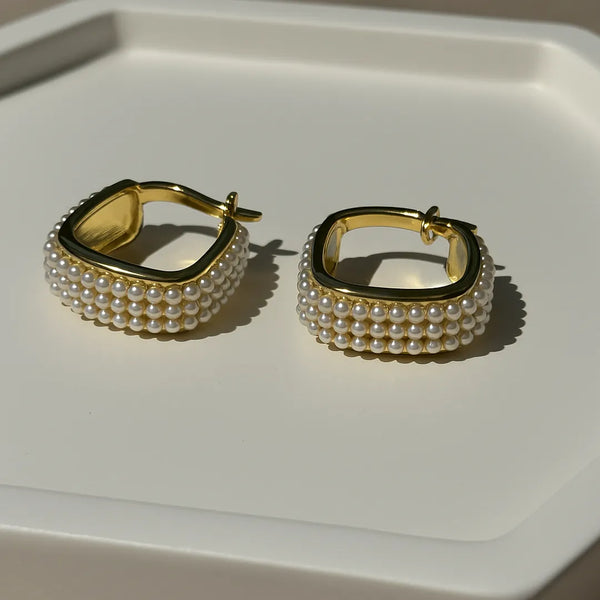 Par de aretes dorados con diseño cuadrado y perlas sobre base neutra – accesorios para mujer con diseño refinado