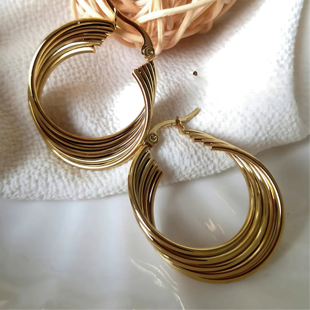 Candongas Multilínea exhibidas en bandeja con tonos dorados y marrón, accesorios para mujer con impacto visual.