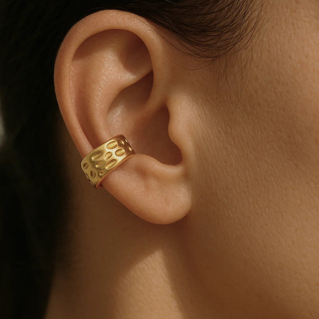 Ear cuff dorado colocado en la oreja sin perforación


