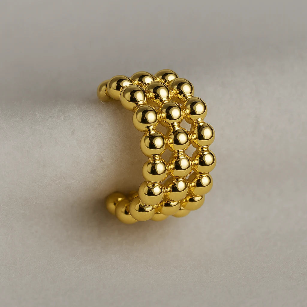 Detalle de textura en ear cuff dorado importado

