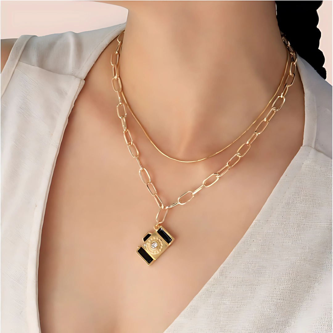 Accesorio dorado de moda con colgante esmaltado en negro

