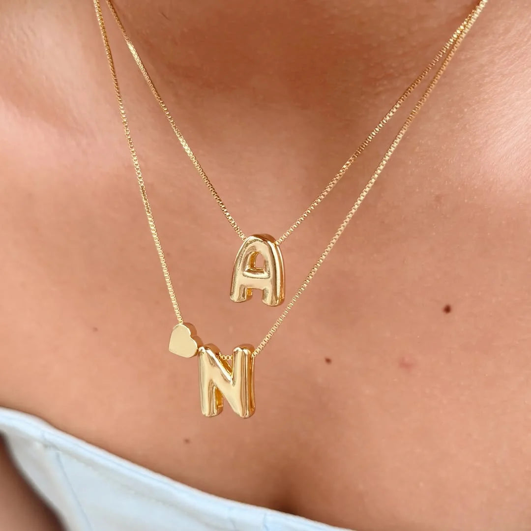 Mujer usando collar con dije de letra grande

