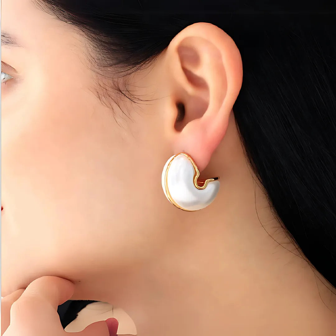 Modelo usando aretes dorados grandes blancos tipo terciopelo

