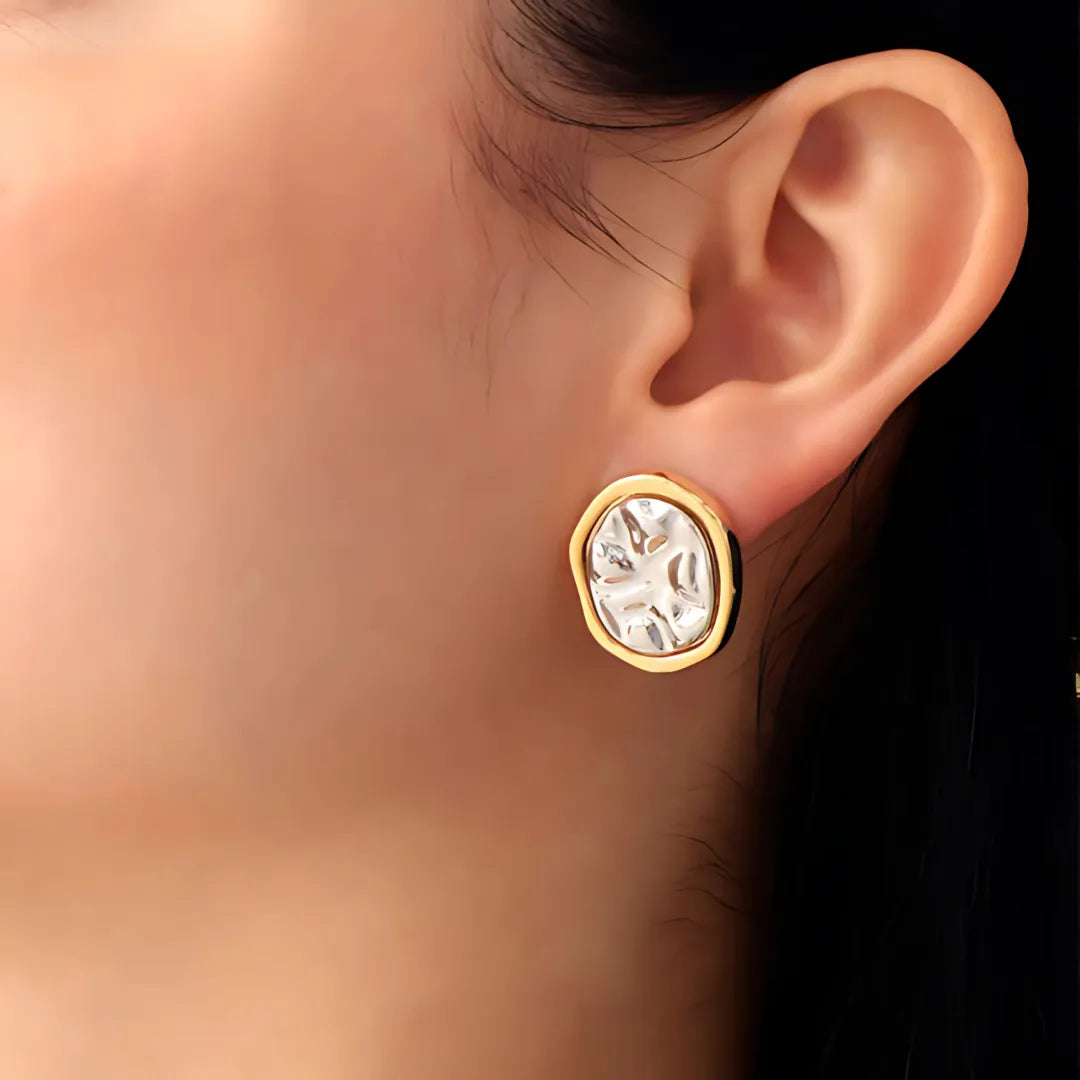 Modelo usando aretes Topo Circular Chunky con textura tridimensional, accesorios para mujer con contraste dorado-plateado.

