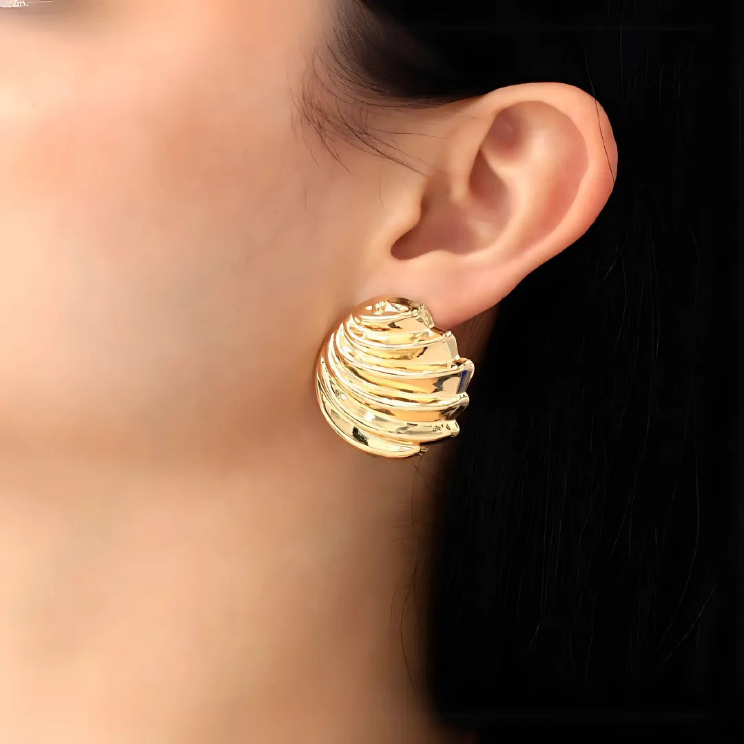 Mujer usando aretes pequeños dorados con forma de llave y corazón – accesorios para mujer modernos