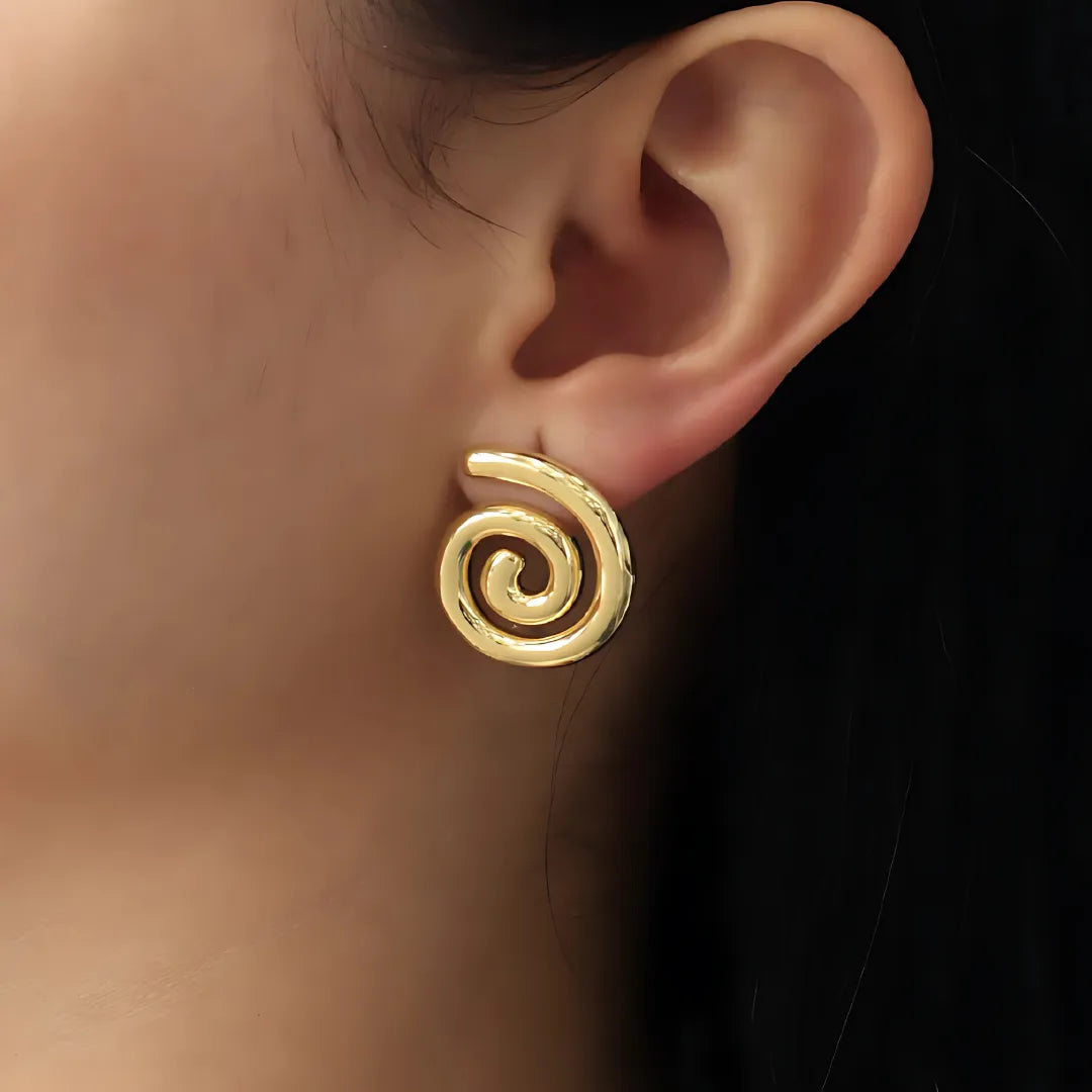 Modelo usando aretes espiral dorados hechos en Colombia

