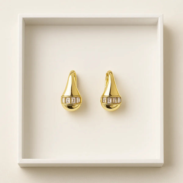 Aretes topo gota dorados con circones en caja, accesorios para mujer con brillo sofisticado.