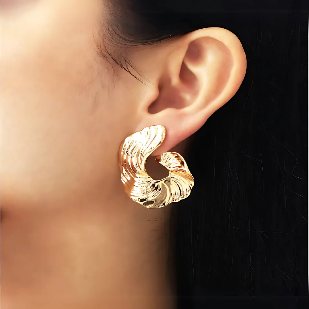 Modelo usando accesorios dorados con diseño colombiano inspirado en la naturaleza

